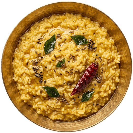 Seen from above: dal masala khichdi in a brass bowl, with curry leaves, mustard seeds and a dried red chilli