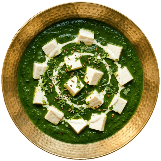 Seen from above: paneer palak in a hammered brass bowl, with a swirl of cream
